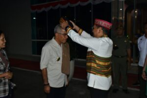 Sekda Fransiskus (kanan) saat menyematkan topi Manggarai pada Pjs. Bupati Ondy. (Foto : Gonsalez)