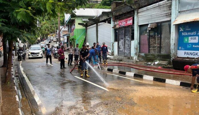 Tim sedang membersihkan lumpur dan material lainya dari jalan raya di Kampung Ujung. (Foto : Ist.)