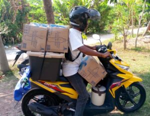Indro, dengan Sepeda Motor hasil usahanya, sedang mengangkut bahan jualan menuju lokasi. (Foto : Dokpri)
