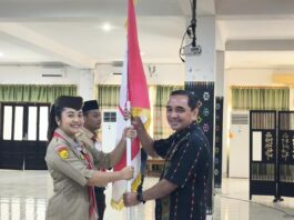 Sekda Fransiskus (kanan) saat menyerahkan bendera Pramuka kepada Ketua Kwarcab, sebagai simbol pelepasan. (Foto : Tildis)