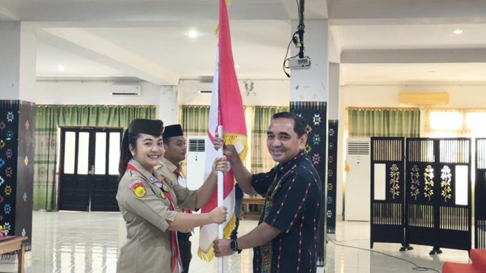 Sekda Fransiskus (kanan) saat menyerahkan bendera Pramuka kepada Ketua Kwarcab, sebagai simbol pelepasan. (Foto : Tildis)