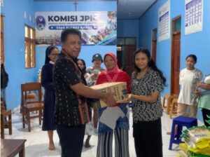 Kepala BKPMSD, Thomas Faran, saat menyerahkan sumbangan