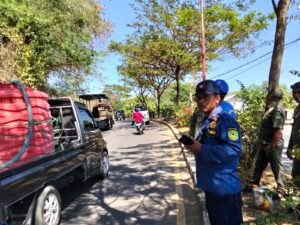Kepala Bidang Damkar sat pol PP Mabar sedang memberikan instruksi kepada anggota yang sedang berusaha memanjat tebing untuk mengevakuasi kayu yang mengacam keselamatan pengguna jalan. foto :Gonsalez