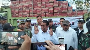 Mentan RI Andi Amran Sulaiman dengan latar belakang truk bermuatan bantuan. (Foto : Mathildis Riberu)